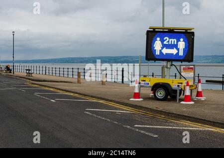 West Kirby, Royaume-Uni: 3 juin 2020: À Marine Lake, un panneau lumineux temporaire encourage les piétons à maintenir la distance sociale due au virus corona Banque D'Images