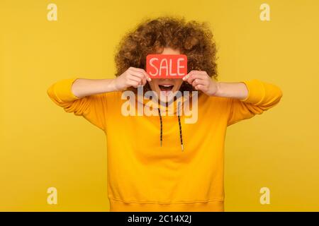 Réduction incroyable sur les achats ! Portrait de femme surprise à poil dur en sweat à capuche de style urbain couvrant les yeux avec inscription Vente, bouche ouverte en amaz Banque D'Images