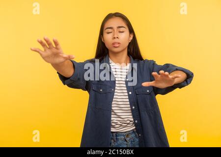 Problèmes de vision. Portrait de aveugle désorienté solitaire fille en denim shirt marchant avec les yeux fermés, levant les mains pour rechercher la route perdue dans l'obscurité. ind Banque D'Images