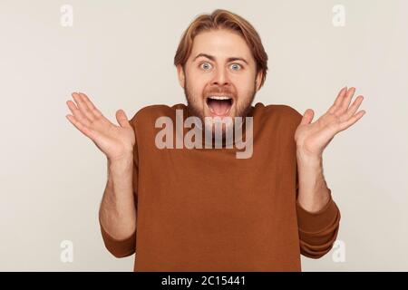 Oh mon dieu, wow! Portrait d'un heureux homme à barbe excité et étonné debout avec la bouche ouverte et hurlant dans un choc soudain, surpris par le suc incroyable Banque D'Images