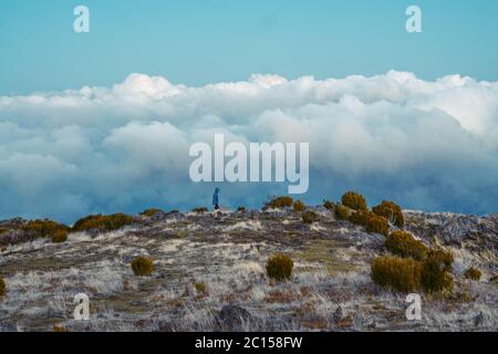 L'homme est seul sur le pic de la roche. Beau moment le miracle de la nature. Brume colorée dans la vallée. Randonnée. Randonnée de Pico do Arieiro à Pico Banque D'Images