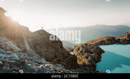 Homme sur une randonnée réussie, silhouette dans les montagnes de la Suisse. Randonneur au sommet de la montagne, avec vue sur un paysage magnifique. Alpes suisses, Europe Banque D'Images