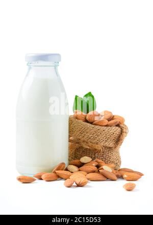 Bouteille de lait et d'amandes noix avec feuille isolée sur fond blanc, les amandes sont des noix très populaires. Les amandes sont riches en gras monoinsaturés sains Banque D'Images