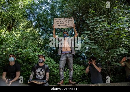 Brighton, Royaume-Uni. 13 juin 2020. Un groupe de jeunes hommes portant un masque de visage se tient sur un mur tenant des plaques, Surplombant la rue remplie de manifestants BLM à Brighton.des activistes locaux en Angleterre ont organisé une manifestation dans le centre de Brighton en solidarité avec les manifestants BLM aux États-Unis pour mettre en lumière le racisme systémique et la brutalité policière au Royaume-Uni. Crédit : SOPA Images Limited/Alamy Live News Banque D'Images