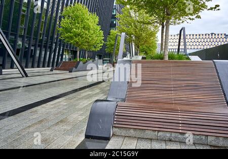 Banc moderne dans le parc près du bâtiment de bureau Banque D'Images