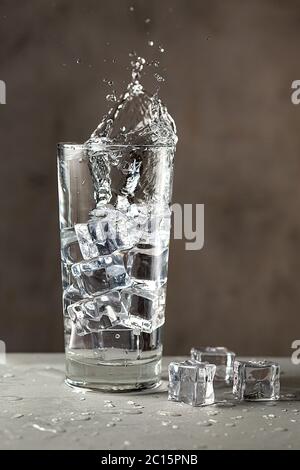 Plongez dans un verre d'eau et de glace. Boisson fraîche et désaltérante pendant la période chaude de l'été. Mise au point douce. Orientation verticale. Banque D'Images