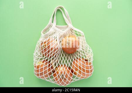 Sac de coton en maille éco avec oignons. Végétarisme. Concept de shopping et de mode de vie écologique. Banque D'Images