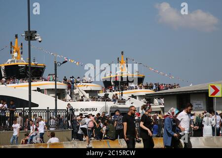 EMINONU, ISTANBUL, TURQUIE; 26 JUIN 2018. Les gens se promenssent dans la rue. Foule à côté du Bosphore, avec mosquée en arrière-plan, à Istanbul. Banque D'Images