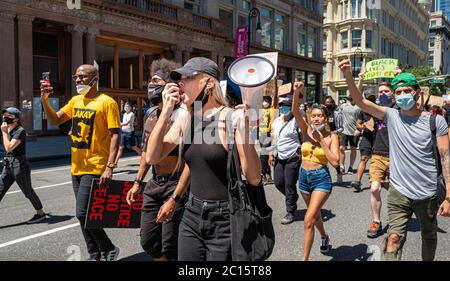 Manhattan, New York, États-Unis - 6 juin 2020 : une jeune femme sur le cornet de Bull marche pour protester contre le meurtre de George Floyd par un policier lors d'une marche BLM. Banque D'Images