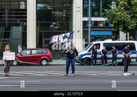 Mitte, Berlin, Allemagne. 14 juin 2020. Unteilbar Demo, manifestation indivisible. Des dizaines de milliers de personnes ont formé une chaîne humaine de 9 kilomètres de long entre la porte de Brandebourg et Hermannplatz, les manifestants manifestaient contre l'exclusion et le racisme, ainsi que pour la solidarité et un avenir social et respectueux du climat. Les participants ont utilisé des rubans en plastique pour maintenir une distance de deux mètres à l'écart pendant la pandémie du virus Corona.Credit: Eden Breitz/Alamy Banque D'Images