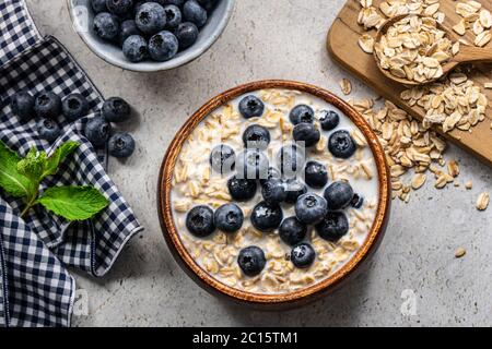 Petit déjeuner sain composé de céréales, de bleuets, de bananes et de miel. Banque D'Images