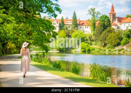 Femme en chapeau dans le parc public au printemps et regardant le château de Pruhonice, République tchèque Banque D'Images