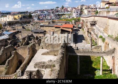 Vue aérienne sur la ville antique, les bâtiments et les fouilles d'Herculanum avec des bâtiments modernes d'Ercolano qui s'élève au-dessus des ruines. Italie Banque D'Images