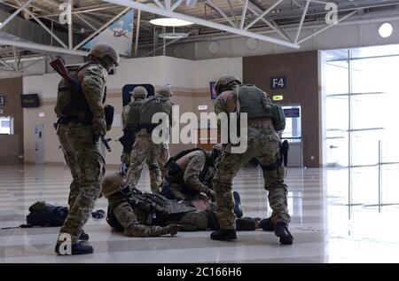 Formation de la police. Soldat de KORD, force de police de grève, SWAT, donnant les premiers soins à son compagnon blessé, d'autres ont pris position Banque D'Images