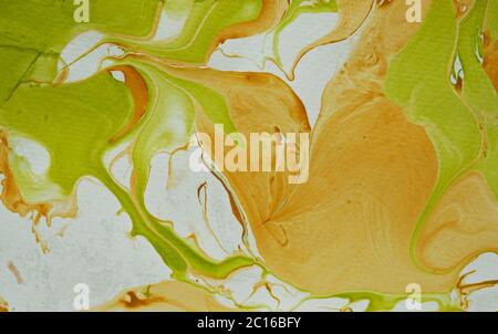 Effet abstrait marbleisé dans des tons mélangés de vert tourbillonnant et d'or dans une texture d'arrière-plan plein cadre Banque D'Images