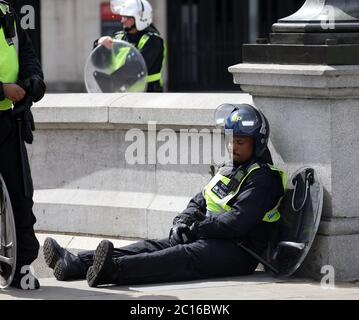 pic montre: L'agent Black épuisé riot cop prend un reniflard après que selon son nom badge il est nommé ÒConstable Black.Ó EDL démo Trafalgar Banque D'Images