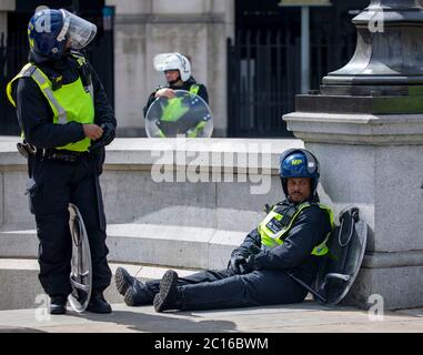 pic montre: Le Constable Black épuisé Riot cop prend un reniflard après que selon son nom badge il est nommé “Constable Black.” Démo EDL Trafalgar Banque D'Images