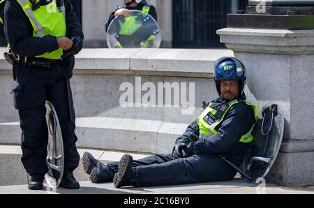 pic montre: L'agent Black épuisé riot cop prend un reniflard après que selon son nom badge il est nommé ÒConstable Black.Ó EDL démo Trafalgar Banque D'Images