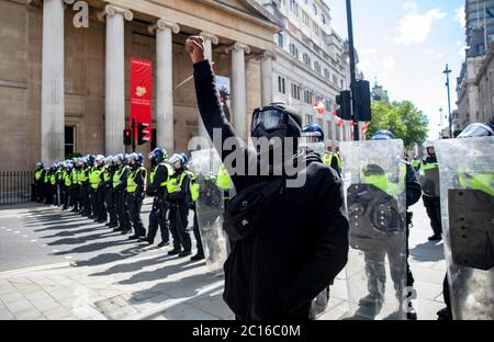 Pic shows: Black Lives Matter supporter devant la police anti-émeute a soulevé sa poing dans défi à Trafalgar Square samedi 13.6.20 photo par GA Banque D'Images