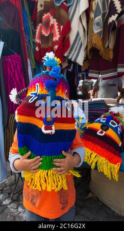 Otavalo, Imbabura / Equateur - janvier 27 2019: Petit garçon jouant avec un masque de diable Huma fait de laine dans le carré des ponchos au centre de Banque D'Images