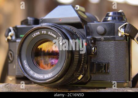 CLUJ-NAPOCA, ROUMANIE - 21 juillet 2012: Éditorial - coucher de soleil dans la forêt reflété dans l'objectif de caméra de film analogique. Banque D'Images