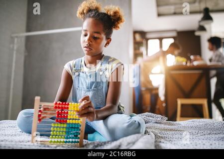 Happy african american girl pour enfants apprendre à compter à la maison avec abacus Banque D'Images