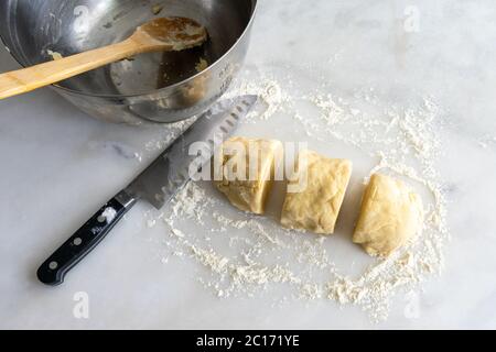 Pâte à zelette Zserbo hongroise : pâte à pâtisserie pétriée coupée en trois morceaux avec un fond de marbre blanc Banque D'Images