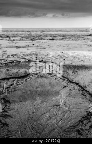 Les retraites d'eau dans l'océan formant des lignes intéressantes dans le sable Banque D'Images