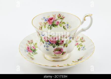 Tasse et soucoupe antique vide avec décoration rose isolé sur blanc - thé anglais Banque D'Images