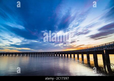 Coucher de soleil derrière le Tay Rail Bridge, Dundee, Écosse, Royaume-Uni. Banque D'Images