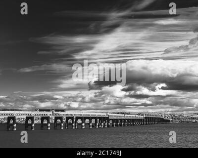 Image monochrome de nuages qui s'amassent au-dessus du pont ferroviaire Tay au départ de Dundee, en Écosse, au Royaume-Uni. Banque D'Images