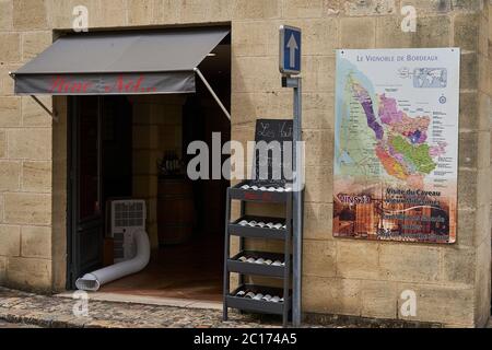 L'extérieur du magasin de vin pas à Saint Emilion à Bordeaux France. Certaines bouteilles sont affichées et une carte des régions viticoles est également affichée. Banque D'Images