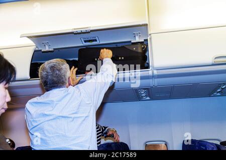 Miami Florida International Airport MIA, aviation, avion, intérieur, intérieur, au-dessus de la tête, rangement, casier, coffre, bagage à main valise suit Banque D'Images