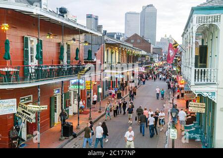 La Nouvelle-Orléans Louisiane, quartier français, Bourbon Street, ligne d'horizon de la ville, rampes en fer, balcons néons panneaux boissons bars hommes femmes couples vie nocturne Banque D'Images