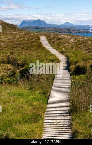 L'homme fait des coupes de chemin côtier en bois à travers le paysage sur l'île de Handa dans la direction sur les hautes terres sur le continent. Écosse Royaume-Uni Banque D'Images