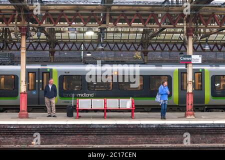 Les passagers du train attendent devant un train London Midland à la gare de Crewe, sur la ligne principale de la côte ouest Banque D'Images