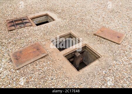 Inspection d'une fosse septique souterraine ou d'un système d'eau de pluie avec couvercle de trou d'homme ouvert, Royaume-Uni Banque D'Images