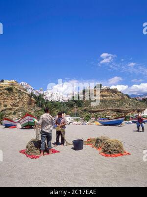 Pêcheurs vérifiant les filets de pêche sur la plage, Nerja, Costa del sol, province de Malaga, Andalousie, Espagne Banque D'Images