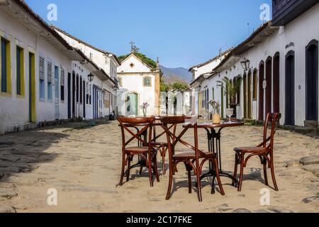 Scène de rue avec table et chaises dans le quartier historique de la ville coloniale de Paraty, Brésil Banque D'Images