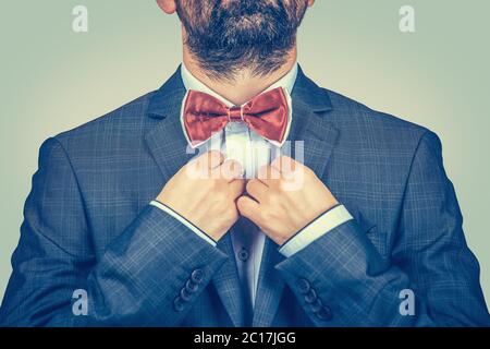 Heureux, barbu homme avec costume foncé, chemise bleue, réglage papillon rouge papillon papillon papillon papillon papillon papillon papillon papillon papillon papillon papillon papillon papillon papillon cravate isolée sur fond vert jaune gradient. Manager souriant et élégant. Banque D'Images