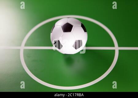 Toy soccer ball in a midfield, in the center of the green field Stock Photo