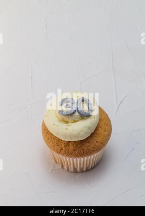 Gâteau de tasse à la vanille avec paillettes argentées numéro 30 sur un moule blanc crémeux Banque D'Images