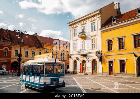 Brasov, Roumanie - 24 juillet 2019 : place médiévale du conseil de la vieille ville et train touristique Banque D'Images