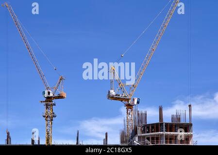 Les grues de construction contre un ciel bleu. Banque D'Images