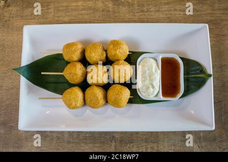 Boule de poisson frite servie avec une sauce Chili et de la mayonnaise. Banque D'Images