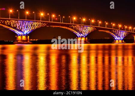 Les lumières nocturnes d'un grand pont de l'autre côté de la rivière se reflètent dans l'eau Banque D'Images