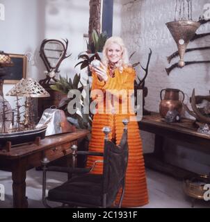 Peggy March, amerikanische Pop- und Schlagersängerin, posiert in einer orangefarbenen Frotteekombination in London, Großbritannien 1970. Peggy March, chanteuse pop américaine, pose dans une combinaison de tissu éponge orange à Londres, Royaume-Uni vers 1970. Banque D'Images