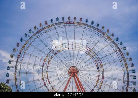 Une grande roue avec des cabines à une foire locale Banque D'Images