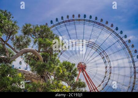 Une grande roue avec des cabines à une foire locale Banque D'Images