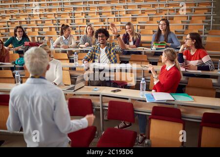 Professeur âgé répondant aux questions des étudiants en amphithéâtre Banque D'Images